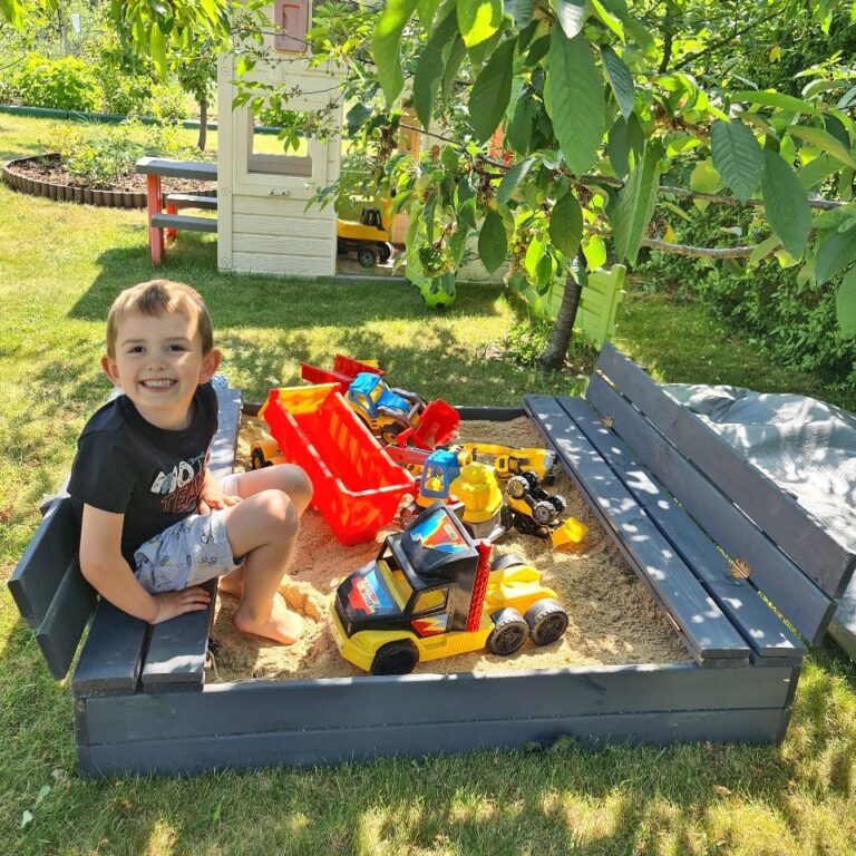 Dziecko w piaskownicy drewnianej